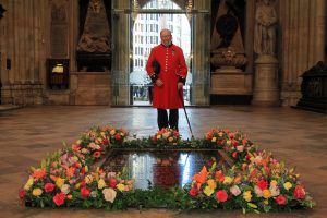A Chelsea Pensioner by the Grave of the Unknown Warrior with Fresh flowers signifying the end of the 1WW.